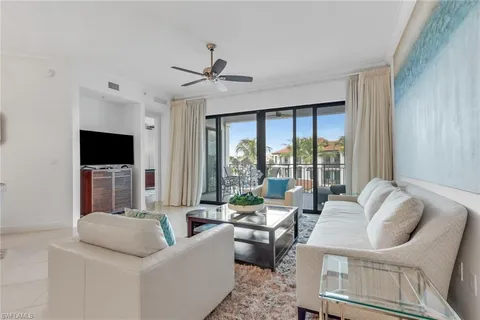 a living room with furniture a flat screen tv and a large window
