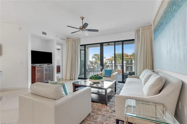 a living room with furniture a flat screen tv and a large window