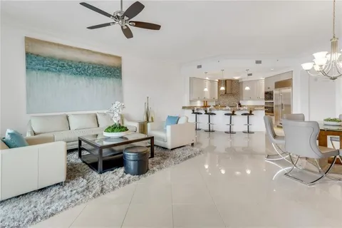 a living room with furniture and a dining table with kitchen view