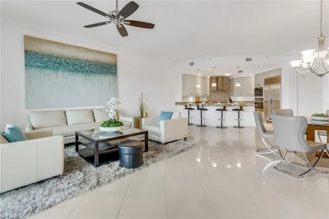 a living room with furniture and a dining table with kitchen view