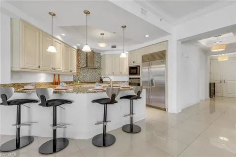 a kitchen with cabinets and chairs