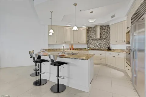 a kitchen with kitchen island granite countertop a sink cabinets and refrigerator