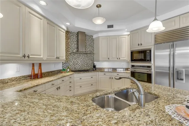 a kitchen with granite countertop a sink stainless steel appliances and cabinets