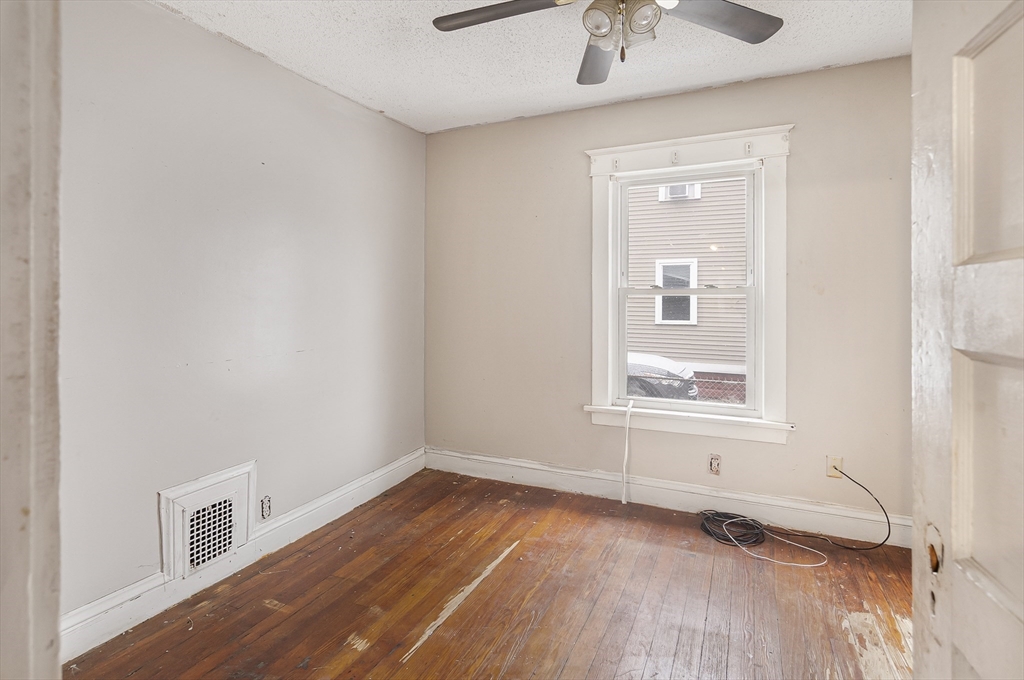 62 Kenyon Street Springfield, MA 01109 - Photo 11 of 19 an empty room with wooden floor and windows