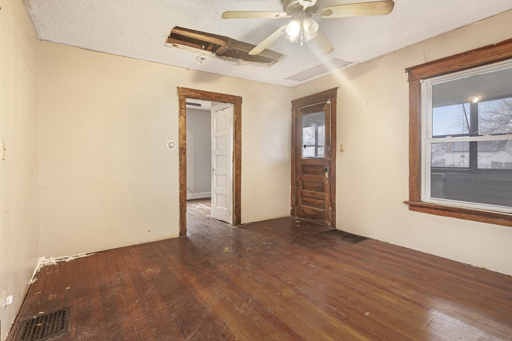 62 Kenyon Street Springfield, MA 01109 - Photo 5 of 19 an empty room with wooden floor fan and windows