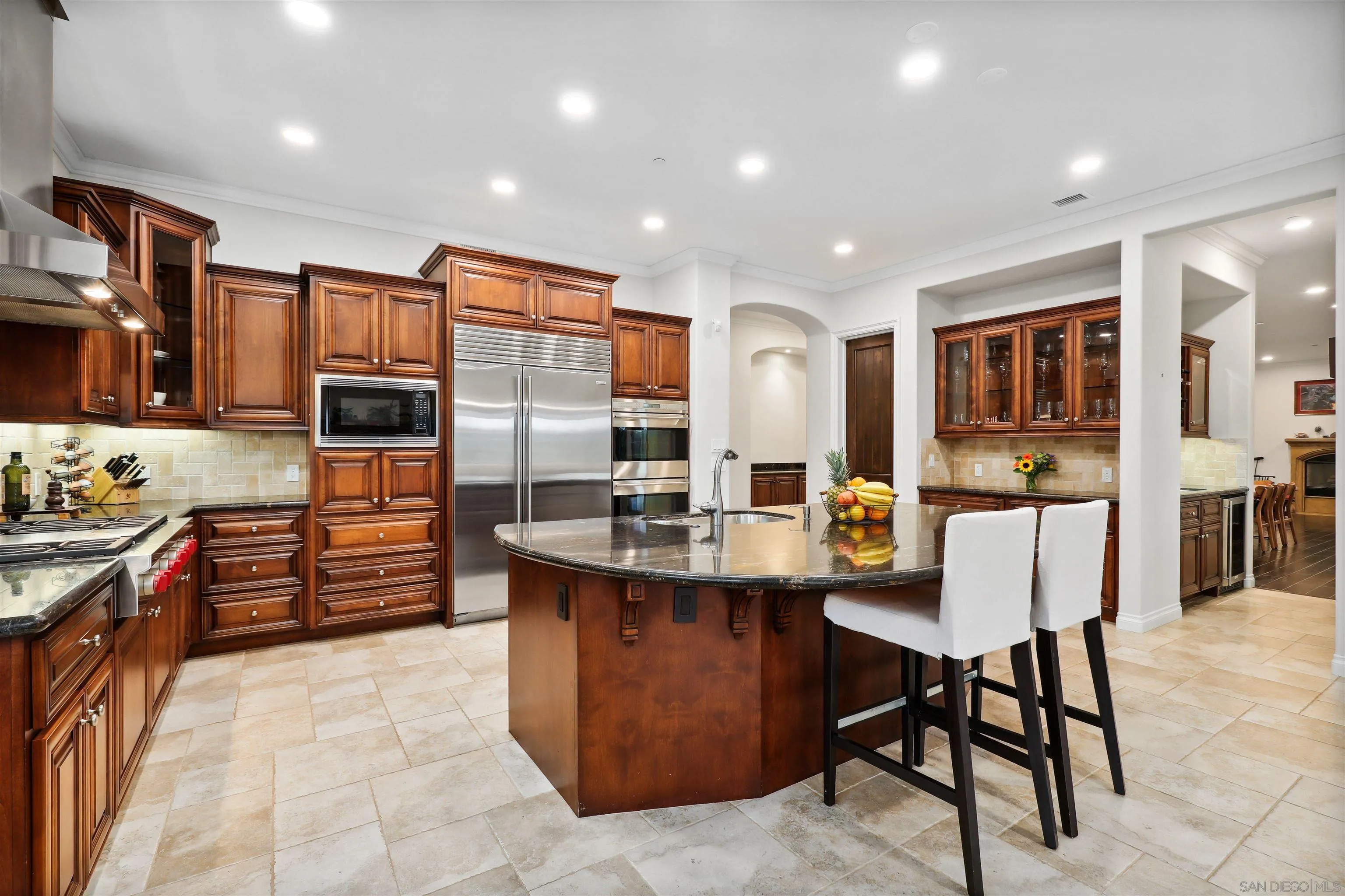 3055 Brookside Lane Encinitas, CA 92024 - Photo 16 of 64 a kitchen with stainless steel appliances kitchen island granite countertop a table chairs and a refrigerator