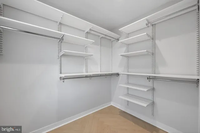 a view of walk in closet with empty racks