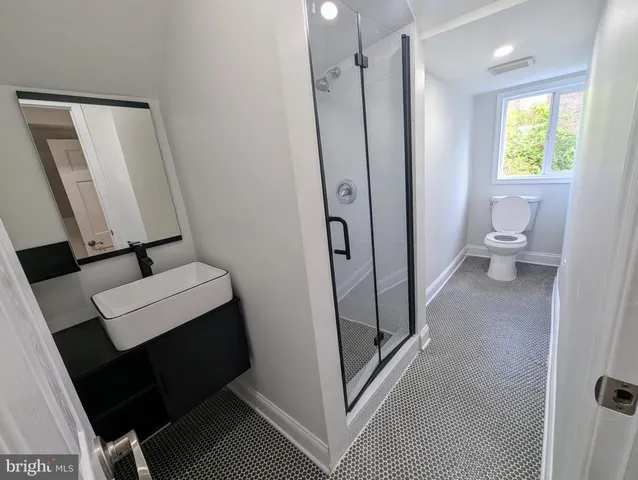 a bathroom with a toilet a sink and a mirror