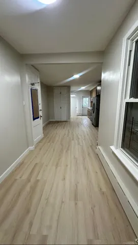 a view of a hallway with wooden floor and a fireplace