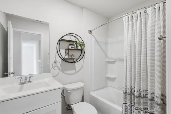 a bathroom with a sink a mirror a toilet and a shower