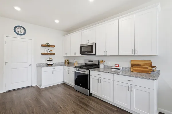 a kitchen with cabinets stainless steel appliances a sink and wooden floor