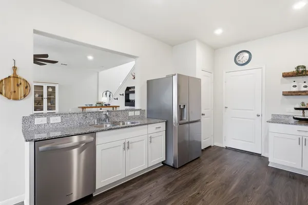 a kitchen with a refrigerator sink and cabinets