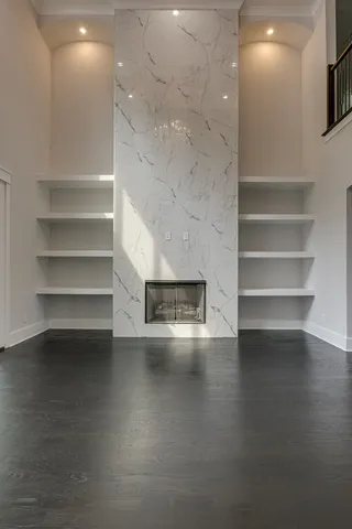 a view of empty room with wooden floor and fireplace