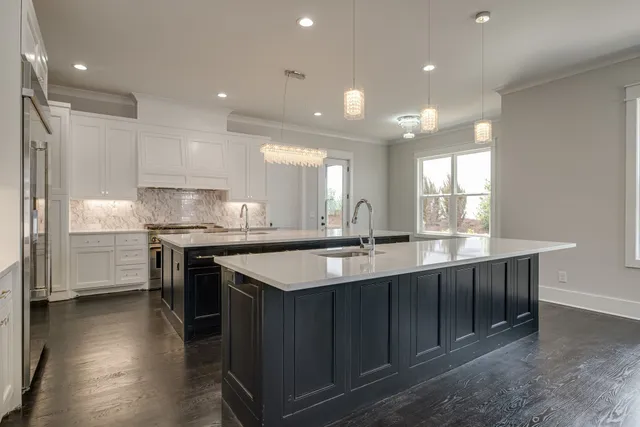 a kitchen with stainless steel appliances granite countertop a sink a stove and a refrigerator