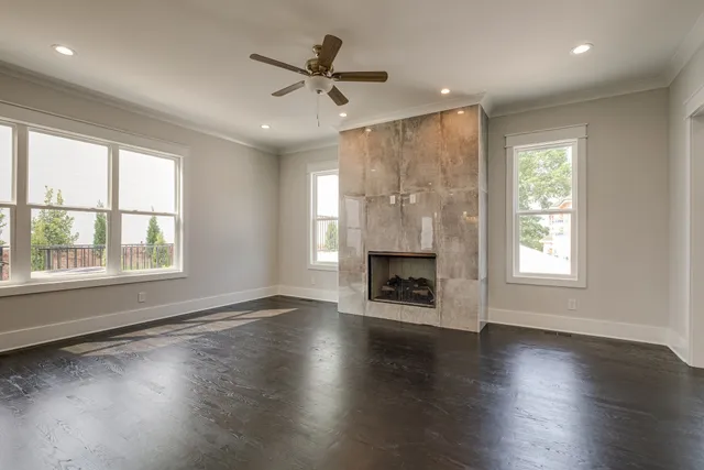 a bathroom with a granite countertop toilet a sink a mirror and a window