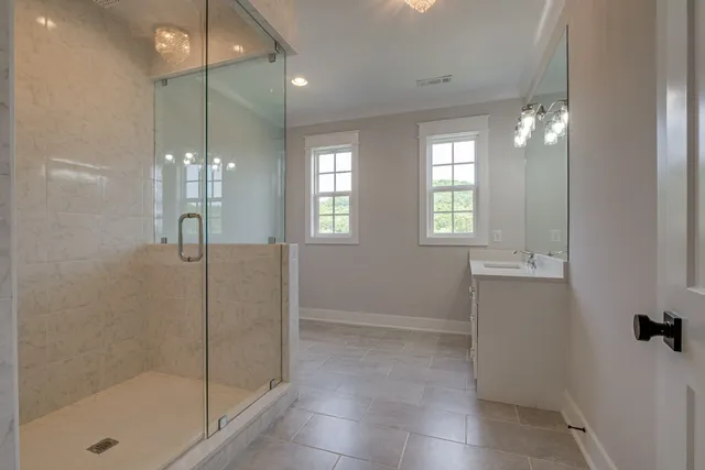 a bathroom with a sink shower and a mirror