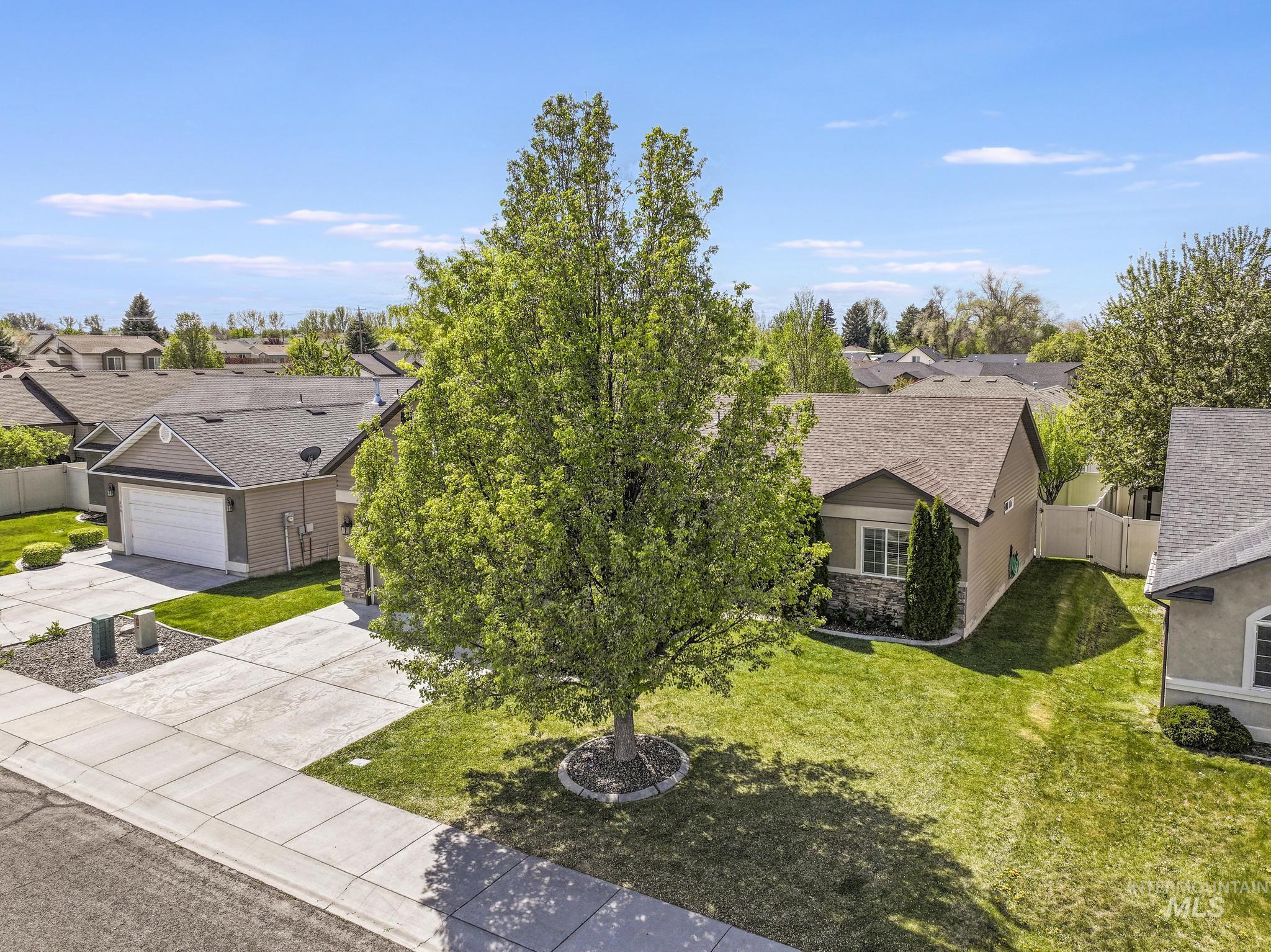446 Noble Street Twin Falls, ID 83301 - Photo 31 of 42 Suburban residence featuring a two-car garage, concrete driveway, and a large front lawn with mature landscaping
