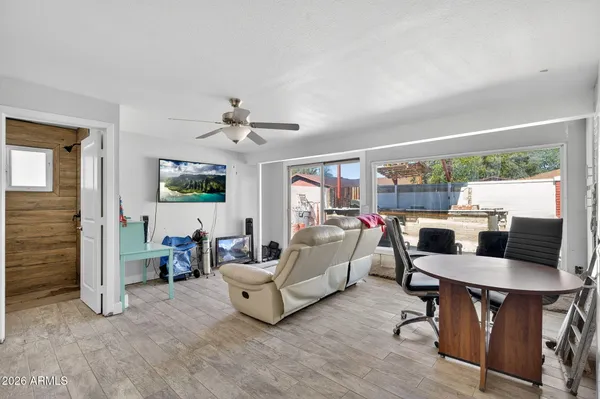 a living room with furniture and a refrigerator