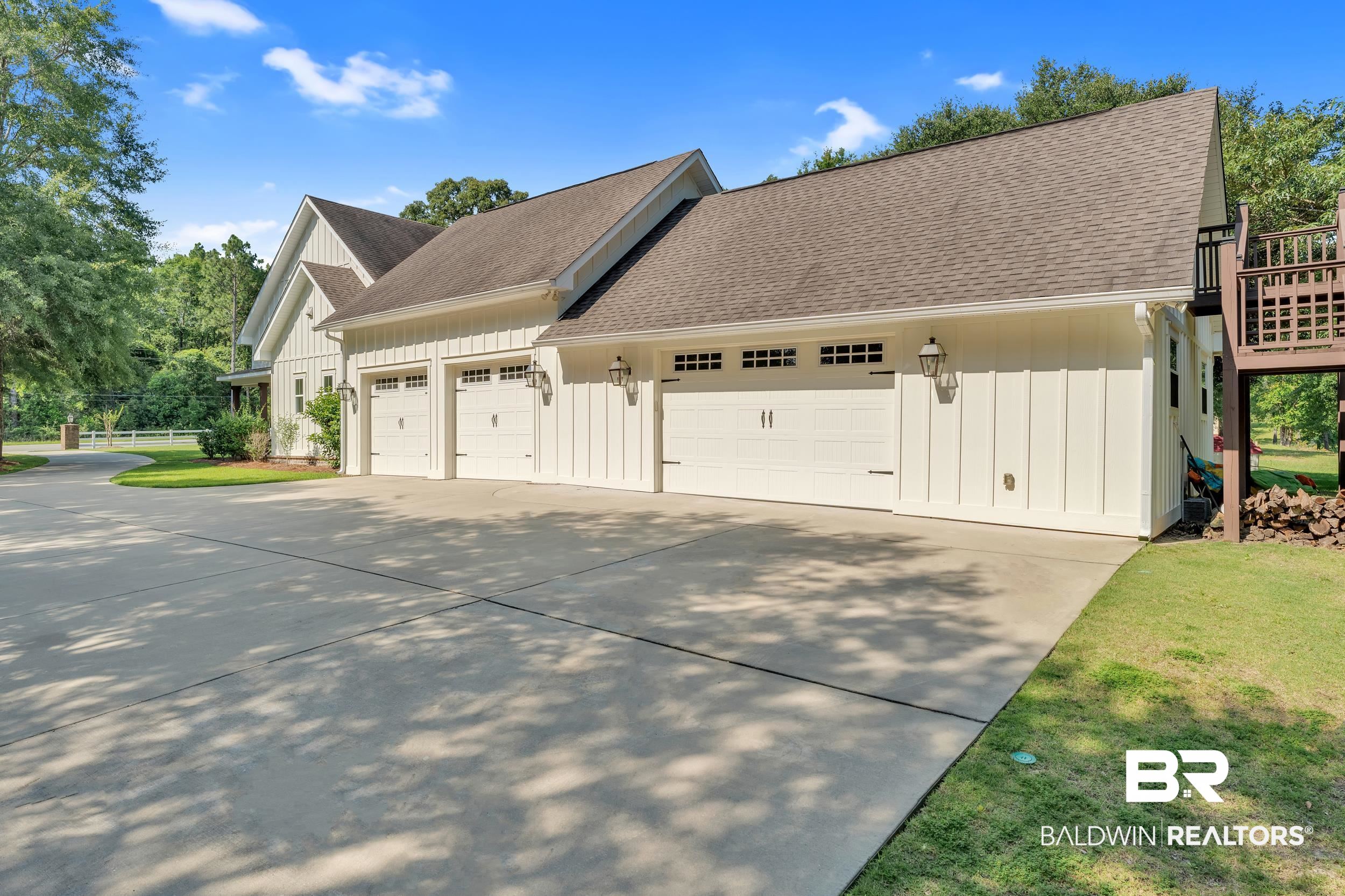 14531 Styx River Road Stapleton, AL 36578 - Photo 41 of 50 View of side of home with board and batten siding, concrete driveway, roof with shingles, and an attached garage