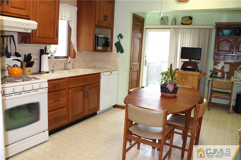 142 Rector Street Perth Amboy, NJ 08861 - Photo 11 of 22 a kitchen with stainless steel appliances a stove a sink dining table and chairs