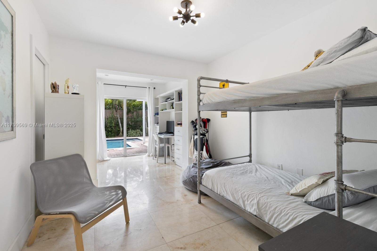 140 West Mashta Drive Key Biscayne, FL 33149 - Photo 13 of 35 a bedroom with a bed and a chair