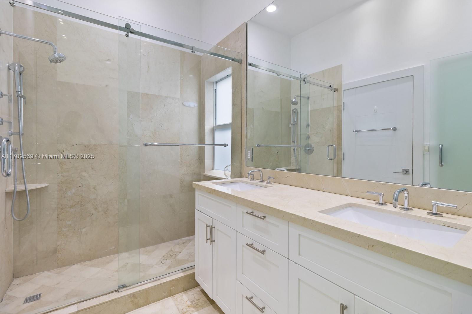 140 West Mashta Drive Key Biscayne, FL 33149 - Photo 17 of 35 a bathroom with a shower sink and mirror