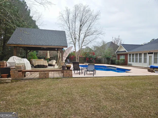 a view of house with outdoor seating and yard