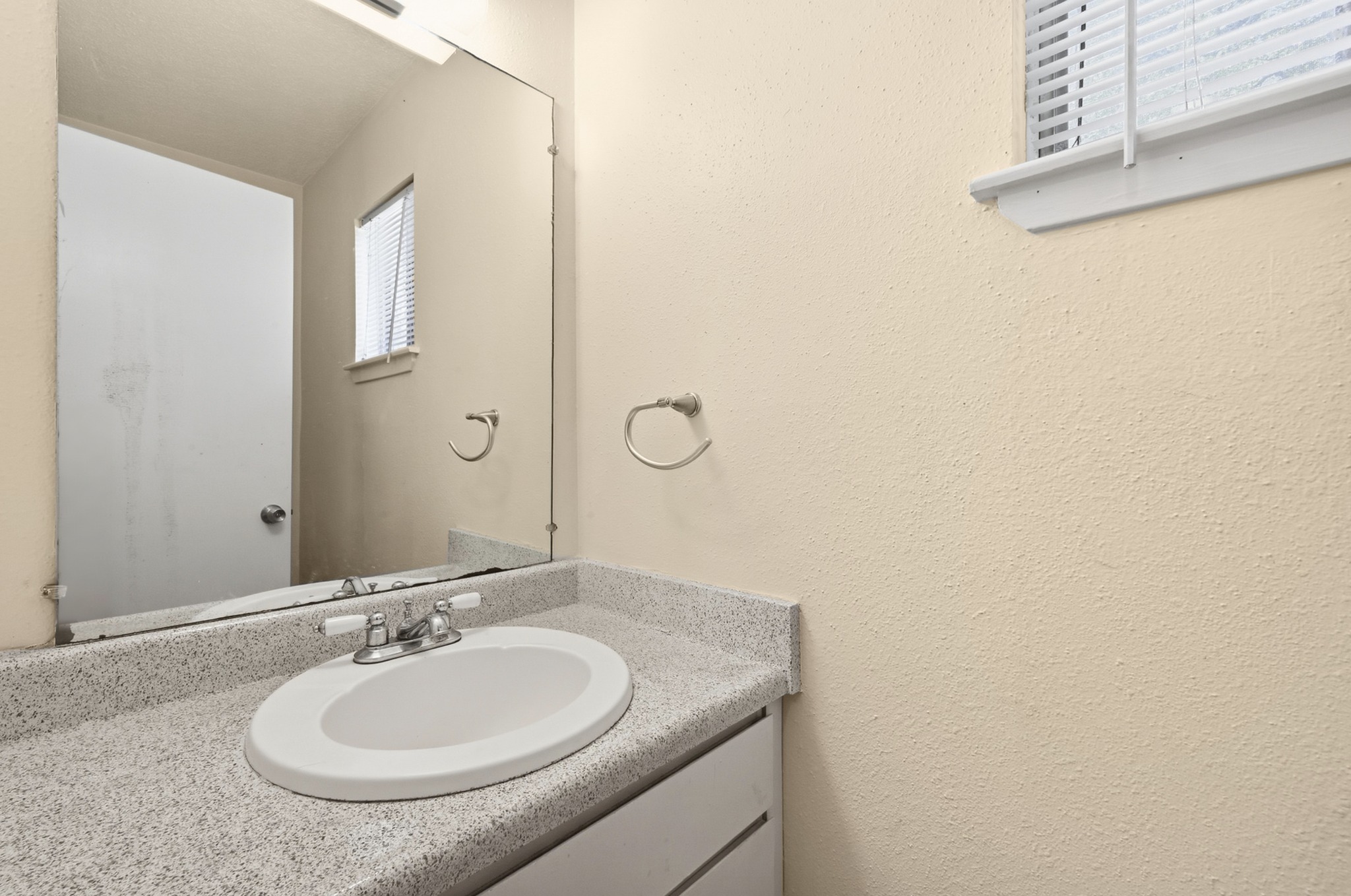 807 Castle Ridge Road, Unit C Austin, TX 78746 - Photo 16 of 26 A classic vanity setup features durable solid surface countertops and a large mirror.