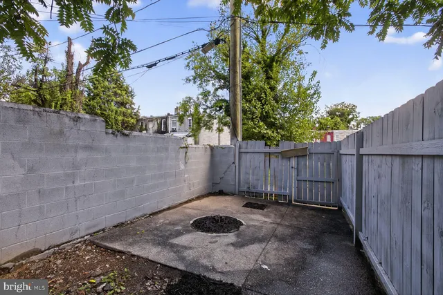 a view of a backyard with a tree and wooden fence