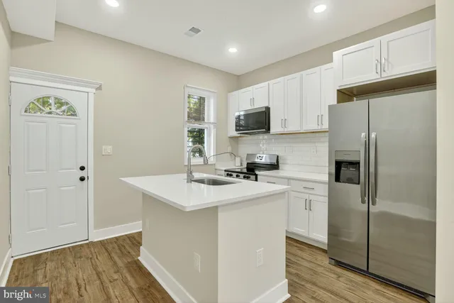 a kitchen with a refrigerator a sink and cabinets