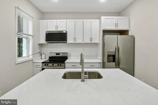 a kitchen with stainless steel appliances a stove a sink a microwave and refrigerator