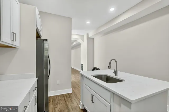 a kitchen with a sink a refrigerator and cabinets