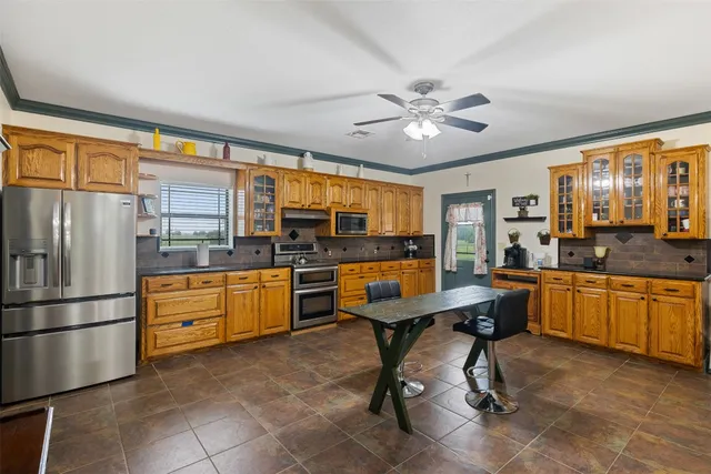 a kitchen with stainless steel appliances kitchen island granite countertop a refrigerator a stove a sink dishwasher with a dining table and chairs with wooden floor