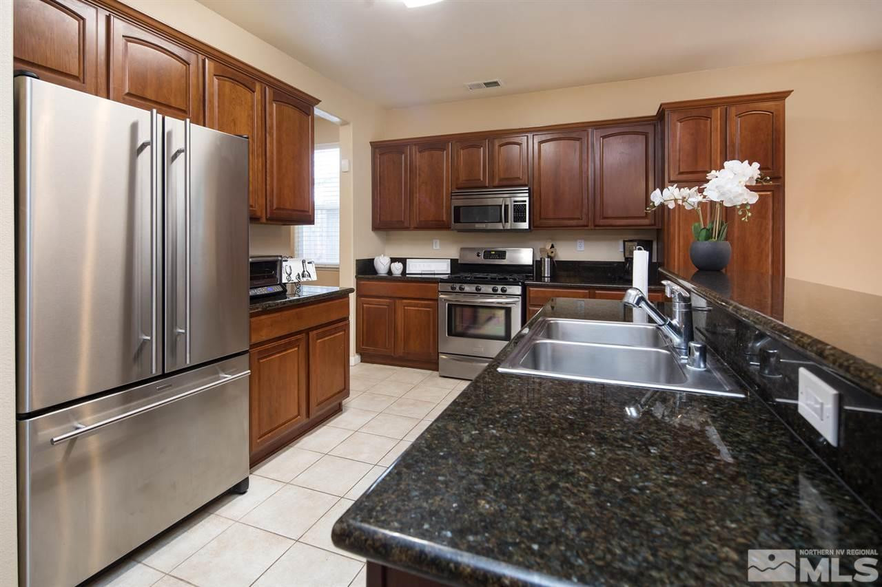 856 North University Park Loop Reno, NV 89512 - Photo 9 of 22 a kitchen with stainless steel appliances granite countertop a refrigerator stove and sink