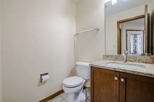 a bathroom with a granite countertop toilet sink and mirror