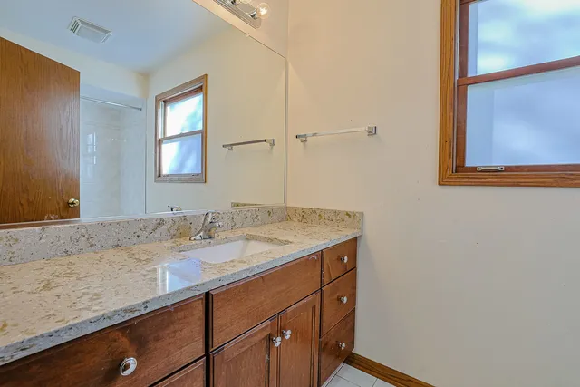 a bathroom with a granite countertop sink and a mirror