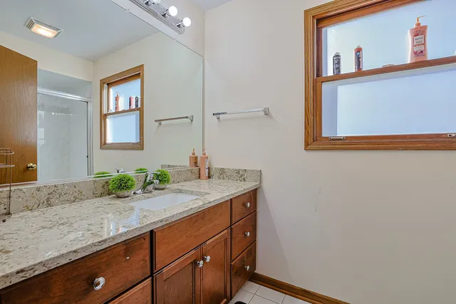 a bathroom with a granite countertop sink and a mirror