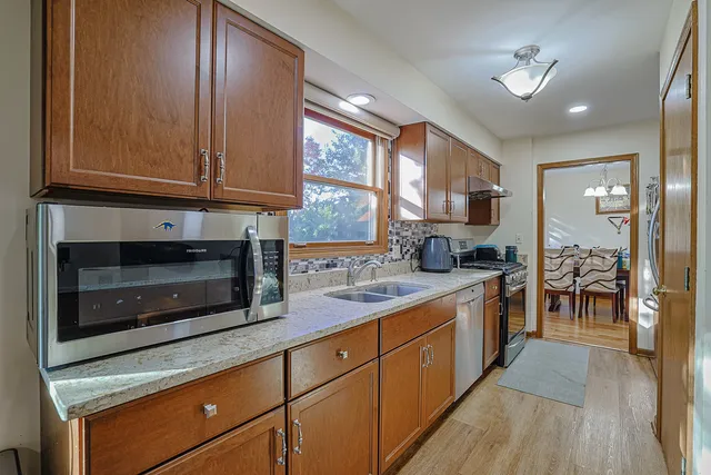 a kitchen with stainless steel appliances granite countertop a stove a sink and a microwave