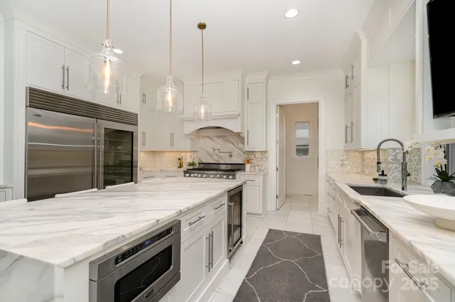 a kitchen with granite countertop a sink and white cabinets