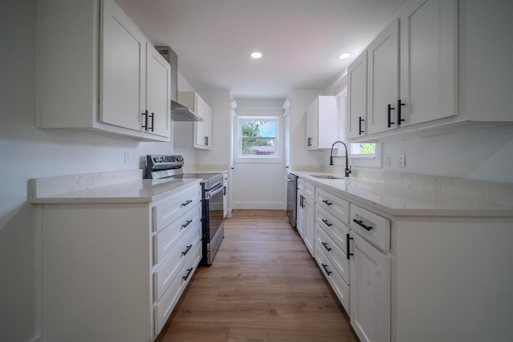 920 Treasure Road Garland, TX 75041 - Photo 7 of 19 a kitchen with white cabinets sink and stove