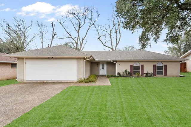 a front view of a house with a garden and yard