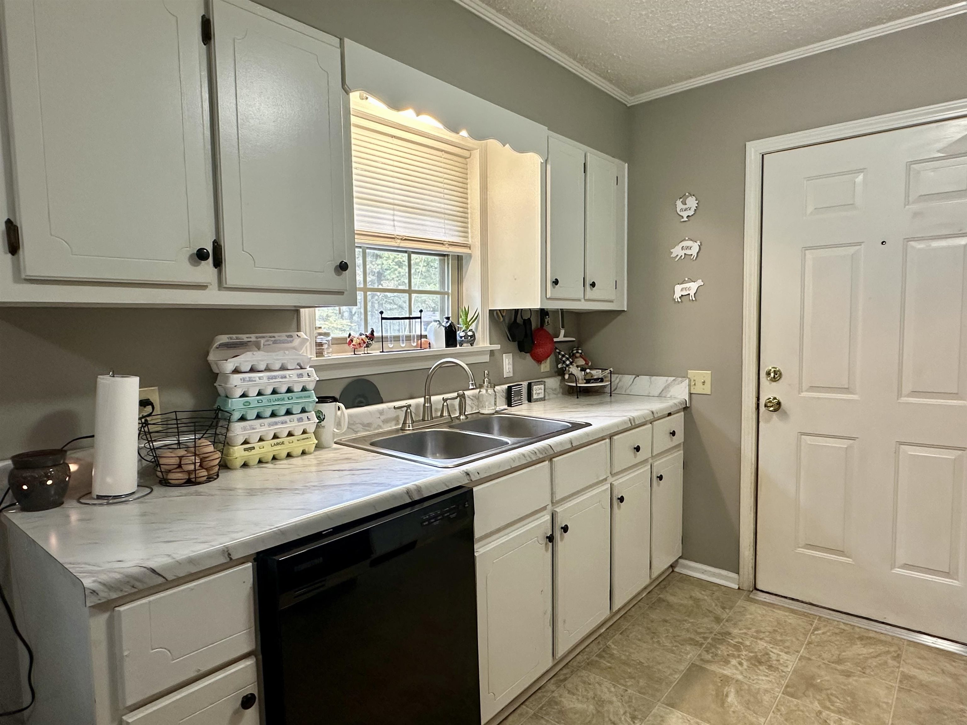 320 Clayton Road Finger, TN 38334 - Photo 5 of 16 Kitchen featuring black dishwasher, light countertops, white cabinetry, crown molding, and a textured ceiling