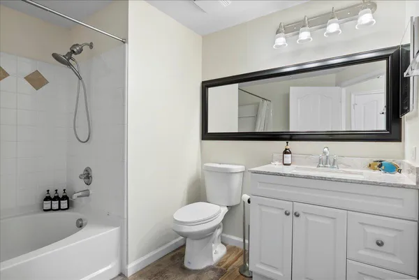 a bathroom with a toilet sink a mirror a bathtub and shower