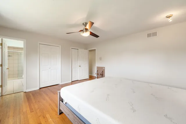 a spacious bedroom with a bed and a chandelier