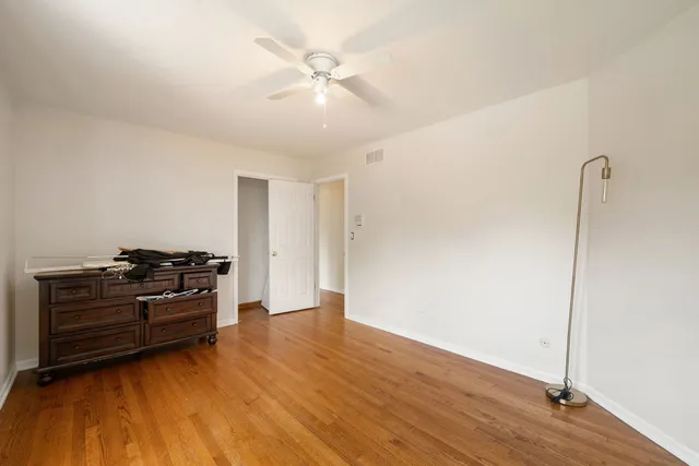 a living room with hard wood floors and a ceiling fan