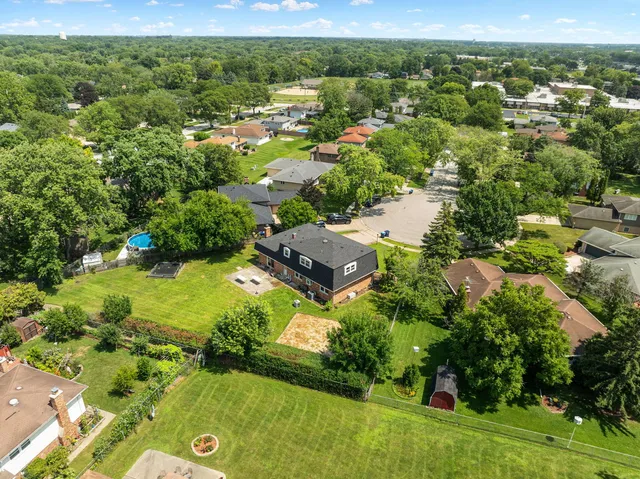 an aerial view of residential houses with outdoor space and trees all around