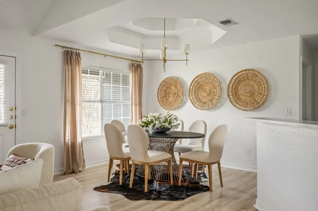a dining room with furniture and a large window