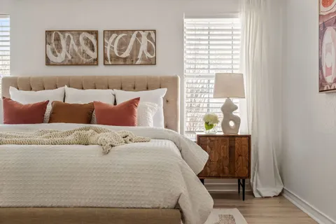 a bed sitting in a bedroom next to a window