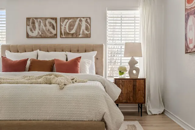 a bed sitting in a bedroom next to a window