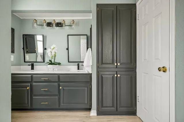 a bathroom with a granite countertop sink and a mirror